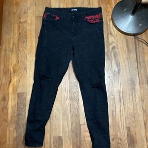 Black skinny jeans with red plaid detail
